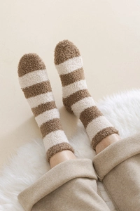 Close-up of thick coral fleece winter socks with brown and white striped texture