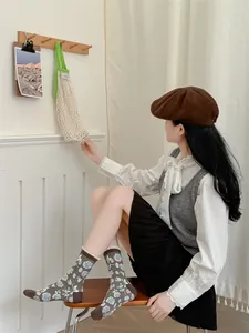 Détail de chaussettes en maille à fleurs vintage avec bordure en dentelle blanche café