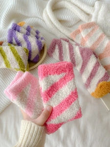Macro detail of plush striped coral fleece socks showing soft texture and warm yarn fabric