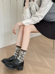 Détail de chaussettes en coton à fleurs vintage avec bordure en dentelle et mocassins