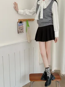 Vue détaillée des chaussettes à fleurs rétro portées avec mocassins et jupe plissée