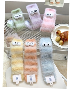 Detailed view of soft coral fleece winter socks with colorful stripes and cute 3D eyes