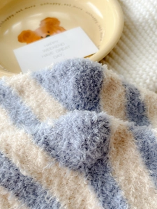 Macro detail of blue and white striped coral fleece socks with soft plush fiber texture