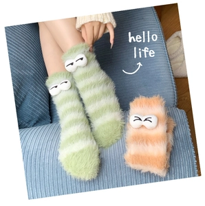 Close-up of thick striped coral fleece socks with cute cartoon 3D eyes decoration