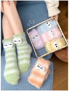 Close-up of thick coral fleece striped socks with cute cartoon eyes in six vibrant colors