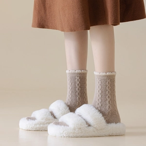 Thick warm white plush slippers and brown cable knit socks for winter home comfort