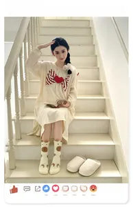 Détail de robe d'intérieur beige en polaire corail avec nœud rouge et chaussettes hautes