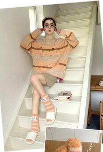 Detail shot of orange striped fuzzy coral fleece socks with cute 3D eye decoration