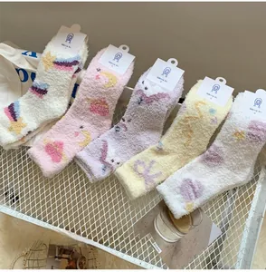 Close-up of five pairs of thick coral fleece socks with celestial star and moon patterns