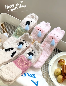 Detail view of plush coral fleece winter socks featuring cute 3D cartoon animal designs