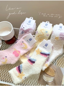 Detail of five pairs of thick coral fleece socks with cute star and moon embroidery