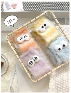 Detail of plush coral fleece socks featuring cute cartoon eye decorations in soft pastel colors