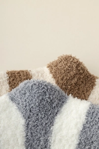 Close-up of soft coral fleece striped socks in grey-blue and brown fuzzy texture