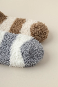 Close-up of soft coral fleece striped socks showing thick plush texture and warm winter material