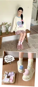 Close-up of soft coral fleece socks with star and moon patterns and plush slippers