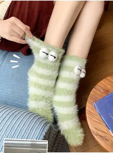 Close-up of green and white striped coral fleece socks with cute 3D plush eyes decoration