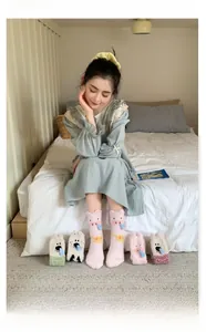 Cozy coral fleece animal socks for women shown in a comfortable bedroom home setting