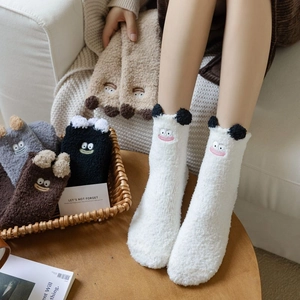 Detailed close-up of fuzzy winter socks with cute cartoon animal ears and embroidery