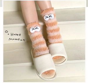 Close-up of thick coral fleece striped socks with cartoon eye patches for winter comfort