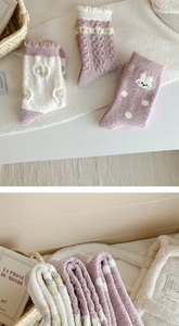 Detail of soft coral fleece socks in pastel colors with cute rabbit patterns and thick texture