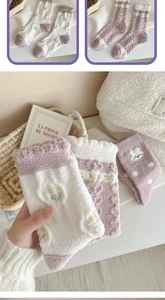 Detailed close-up of fluffy winter socks featuring cute rabbit embroidery and wavy cuffs