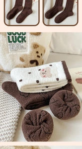 Detail view of thick coral fleece socks with cute bear patterns and warm plush texture