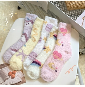 Close-up of soft coral fleece socks with cute star and unicorn patterns for winter
