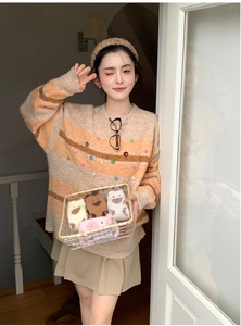 Détail d'un pull à rayures et de chaussettes animaux douillettes dans un panier