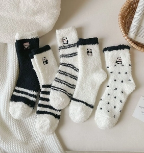 Detail of five pairs of thick coral fleece panda socks in soft plush material