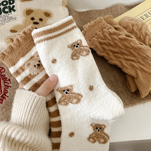 Gros plan de chaussettes épaisses en polaire corail avec broderie ours et rayures