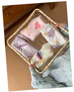Detail of soft coral fleece socks with cute star and moon patterns in a basket