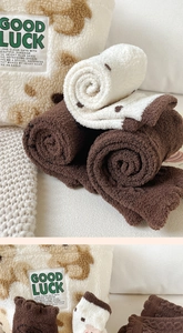 Detail of plush winter thermal socks with teddy bear embroidery and Good Luck label