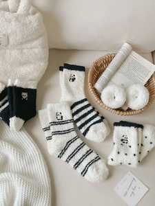Close-up of warm coral fleece socks with cute panda embroidery and black white stripes