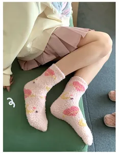 Close-up of pink coral fleece socks featuring cute starry sky moon and planet embroidery