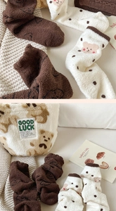 Detail of soft coral fleece socks and hat featuring brown bear patterns and woven labels