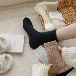 Detailed close-up of thick cable knit thermal socks in various neutral winter colors