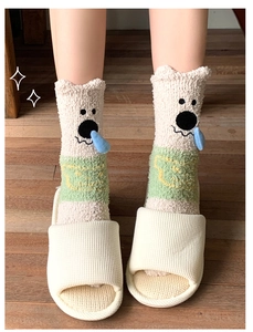 Detail of warm coral fleece mid-tube socks with cute cartoon design on wooden floor
