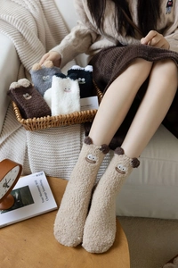 Close-up of thick coral fleece socks with cute cartoon embroidery and animal ear details