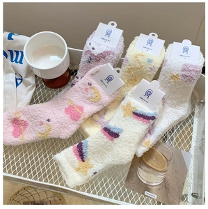 Detailed view of plush coral fleece socks with star and moon patterns in soft pastel colors