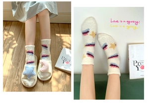 Detail of soft white coral fleece socks with colorful stripes and yellow star patterns