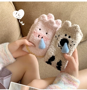 Close-up of cute pink pig and beige koala coral fleece socks with 3D details