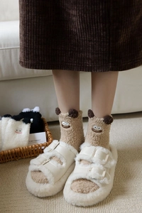 Detail of khaki cartoon coral fleece sock with plush ears and white buckle slippers