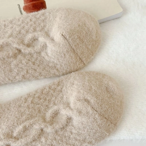 Macro detail of beige cable knit thermal socks with warm coral fleece inner texture