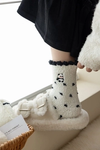 Macro detail of white coral fleece panda socks with black scalloped trim and cozy plush texture