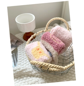 Three pairs of thick coral fleece socks with star patterns in a cozy wire basket