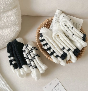 Thick coral fleece socks featuring black and white striped and polka dot patterns