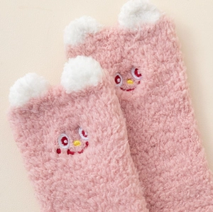 Détail de chaussettes en molleton corail rose avec oreilles 3D et broderie cartoon