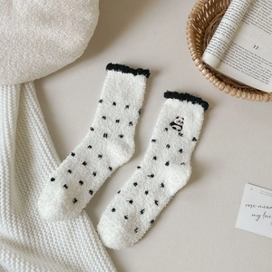 Detail of coral fleece socks with cute panda embroidery and black polka dot pattern