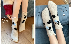 Detail of warm off-white coral fleece socks with black polka dots and cute koala ears