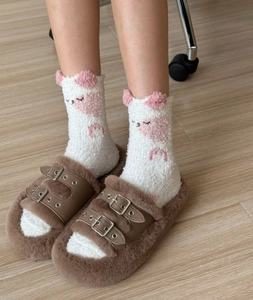 Détail de pantoufles marron à boucles avec chaussettes mignonnes à oreilles de chat